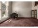 Bright living room with grand piano, large window, and decorative cabinet at 5365 W Princeton Dr, Denver, CO 80235