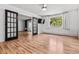 Bright bedroom features a TV, wood floors, large window, and black french doors at 705 S Alton Way # 6B, Denver, CO 80247