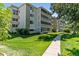 Exterior building view with sidewalk, manicured lawn, and mature trees at 705 S Alton Way # 6B, Denver, CO 80247