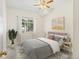 Bright bedroom featuring a ceiling fan, large window, and cozy bed with stylish pillows and a rug at 10784 W 63Rd Pl # 205, Arvada, CO 80004