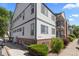Exterior view of building, with light siding, dark trim, brick foundation, and manicured landscaping at 10784 W 63Rd Pl # 205, Arvada, CO 80004