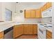 Functional kitchen featuring bright cabinets, white appliances, plenty of counter space, and hardwood floors at 10784 W 63Rd Pl # 205, Arvada, CO 80004