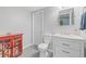 Bathroom with a modern vanity, toilet, and gray tile flooring, plus red cabinet at 9530 Gray St, Westminster, CO 80031