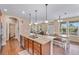 Open layout showcasing the kitchen island, living area, and dining nook with lots of natural light at 9530 Gray St, Westminster, CO 80031