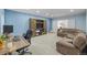 Open-concept living room with blue walls, a sectional sofa, desk, and a decorative cabinet at 9530 Gray St, Westminster, CO 80031