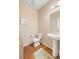 Cozy powder room featuring a pedestal sink, hardwood floors, and neutral decor creating a welcoming space at 9530 Gray St, Westminster, CO 80031