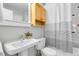 Clean bathroom featuring a pedestal sink, toilet, and a shower with a stylish shower curtain at 12031 E Ford Cir, Aurora, CO 80012