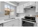 Well-lit kitchen featuring stainless appliances, light countertops, and a large window at 12031 E Ford Cir, Aurora, CO 80012