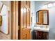Stylish powder room with wood vanity, white sink, decorative mirror, and fixtures at 4565 Pussywillow Ct, Boulder, CO 80301