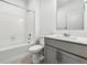 Bright bathroom with a shower-tub combo, gray vanity, and tile floors at 13465 Valentia Pl, Thornton, CO 80602