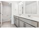 Modern bathroom with double vanity, stylish lighting, and separate toilet and shower area at 13465 Valentia Pl, Thornton, CO 80602