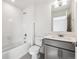 Bathroom featuring white tiled walls, bathtub, toilet, and vanity with a gray cabinet at 13465 Valentia Pl, Thornton, CO 80602