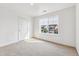 Bright bedroom with neutral carpet and a large window with views of the neighborhood at 13465 Valentia Pl, Thornton, CO 80602