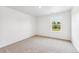 Empty bedroom featuring neutral carpet, and window view of the yard at 13465 Valentia Pl, Thornton, CO 80602