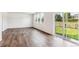 Spacious living room featuring hardwood floors, large windows, and sliding glass door at 13465 Valentia Pl, Thornton, CO 80602