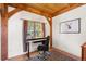 Bright home office featuring wood ceiling beams, hardwood floors, and desk facing window with views at 13326 Kuehster Rd, Littleton, CO 80127