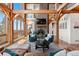 Bright living room boasts a stone fireplace, wood beam construction, and expansive windows with views at 13326 Kuehster Rd, Littleton, CO 80127