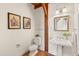 Elegant powder room with pedestal sink, toilet, and wood beams at 13326 Kuehster Rd, Littleton, CO 80127