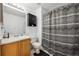 Bathroom featuring a vanity, toilet, cabinet and a shower with black and grey patterned shower curtain at 7840 Ogden Ct, Denver, CO 80229