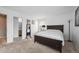 Bedroom with neutral carpet, a large bed frame, and mirror stand near an en-suite bathroom at 7840 Ogden Ct, Denver, CO 80229