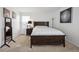 Well-lit bedroom with neutral carpet, a large bed frame, and a dark bedside table at 7840 Ogden Ct, Denver, CO 80229