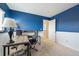 Comfortable home office with blue accent wall and a desk with a comfortable office chair at 7840 Ogden Ct, Denver, CO 80229