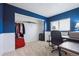 Home office with blue accent wall, a closet, a desk, and a comfortable office chair at 7840 Ogden Ct, Denver, CO 80229
