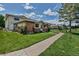 View of the exterior featuring stone facade with a healthy green lawn, and sidewalk that leads to the property at 3354 S Flower St # 52, Lakewood, CO 80227