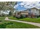 View of the exterior featuring stone facade and a lovely wooden deck with green lawn at 3354 S Flower St # 52, Lakewood, CO 80227