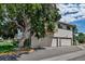 Two-story apartment building featuring neutral siding, private balcony, and individual garages surrounded by mature trees at 3354 S Flower St # 52, Lakewood, CO 80227