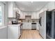 Bright kitchen features white cabinets, stainless steel appliances, and light wood flooring at 3354 S Flower St # 52, Lakewood, CO 80227