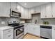 Modern kitchen with stainless steel appliances, quartz countertops, and white cabinets, offering a clean and stylish design at 3354 S Flower St # 52, Lakewood, CO 80227