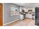 Well-lit kitchen with modern appliances, white cabinets, and wood-look flooring adding a touch of warmth at 3354 S Flower St # 52, Lakewood, CO 80227