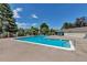 Community pool with sparkling blue water, surrounded by mature trees and comfortable seating areas at 3354 S Flower St # 52, Lakewood, CO 80227