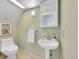Compact bathroom with pedestal sink, toilet, and framed mirror cabinet and neutral walls at 3424 N Marion St, Denver, CO 80205