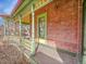 Close up of the Victorian's porch showing painted wood floors and brick siding at 3424 N Marion St, Denver, CO 80205