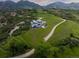 Aerial view of a luxury home set on a sprawling green landscape with winding roads at 15175 W Belleview Ave, Morrison, CO 80465