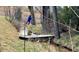 Backyard area with a Personal swinging on a rope swing over a creek in a wooded area at 15175 W Belleview Ave, Morrison, CO 80465