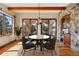 Charming dining room featuring a marble table, stone accents, wood beams, and lots of natural light at 15175 W Belleview Ave, Morrison, CO 80465