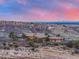 Sunset shot of stone accented house set on a ridge with views of Denver at 15175 W Belleview Ave, Morrison, CO 80465