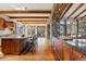 Open kitchen with stone pillar, countertops with seating, exposed beams, and scenic views, perfect for gathering at 15175 W Belleview Ave, Morrison, CO 80465