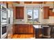 Well-equipped kitchen featuring wooden cabinets, stainless steel appliances, and a large window with mountain views at 15175 W Belleview Ave, Morrison, CO 80465