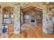 Spacious living room with stone walls, wood beams, and a fireplace, creating a warm and inviting atmosphere at 15175 W Belleview Ave, Morrison, CO 80465