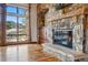 Spacious living room featuring a stone fireplace, large window with mountain views, and hardwood floors at 15175 W Belleview Ave, Morrison, CO 80465