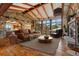 Inviting living room with stone accent walls, wooden beamed ceiling, and large windows framing mountain views at 15175 W Belleview Ave, Morrison, CO 80465
