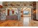 Open-concept living area featuring stone archways, wooden beams, and rich hardwood flooring at 15175 W Belleview Ave, Morrison, CO 80465