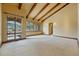 Large living room with high ceilings, wooden beams, neutral walls, and scenic mountain views at 15175 W Belleview Ave, Morrison, CO 80465