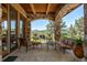 Covered patio with stone pillars, wooden beams, comfortable seating, and mountain views at 15175 W Belleview Ave, Morrison, CO 80465