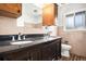 Bathroom with double sink, dark wood vanity, and tile backsplash ready for modern updates at 3306 S Uinta Ct, Denver, CO 80231