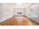 Bright living room featuring hardwood floors, white walls, and a large bay window at 3306 S Uinta Ct, Denver, CO 80231